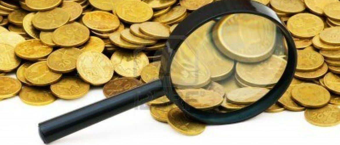 magnifying-glass-and-lots-of-gold-coins-1170×500